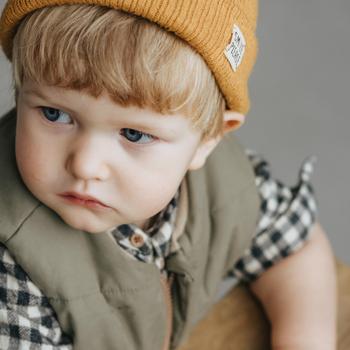 A Little Boy in a Vest and a Beanie