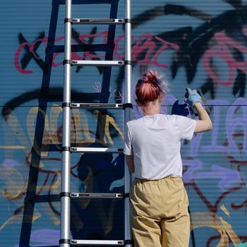 A Woman Doing a Graffiti on a Wall