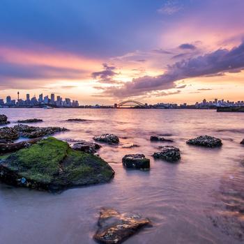 Sydney city buildings beach rock sunset