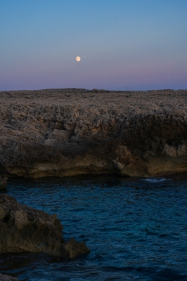 Sea near rough mounts under sky with moon HD WALL